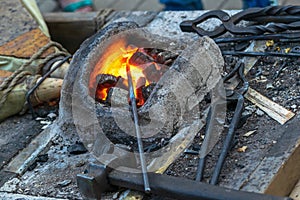 Blacksmithing, a red-hot piece of iron in a forge furnace