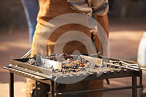 Blacksmiths forge horseshoes. Heated metal for forging according to the ancient method. An old blast furnace. Workshop