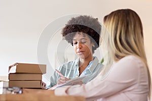 Blackwoman discussing parcel with colleague