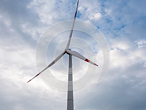 Blades on tower of Eletric power generator wind turbine at sunset against cloudy sky. Close-up. Adyghe wind farm