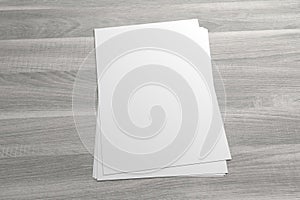 Blank 3D illustration stack of flyer or leaflet on wooden background