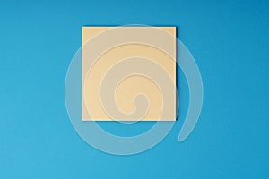 Blank adhesive note on blue background