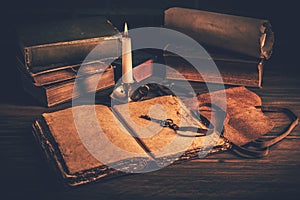 Blank antique leather-bound journal, book or diary with old books and candle