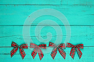 Blank antique teal blue weathered wooden wall with red plaid Christmas bow border