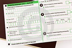 Blank Australia Outgoing passenger card on reddish brown passport on white background.