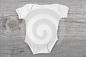 Blank Baby Onesie Mockup on Weathered Wood Background