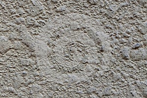 The blank background of the uneven rough wall is light gray yellow. The texture of a concrete, puttyed, plastered and