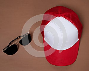 Blank baseball caps are used for design mockups. The hat on the side of an old camera and sunglasses.