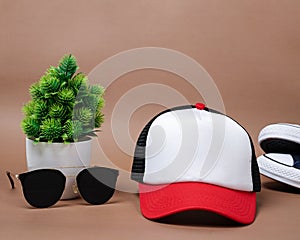 Blank baseball caps are used for design mockups. The hat on the side of an old camera and sunglasses.