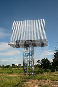 Blank billboard on the background of the road and blue sky.