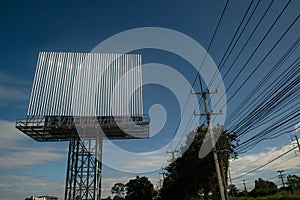 Blank billboard on the background of the road and blue sky.