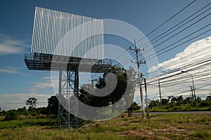 Blank billboard on the background of the road and blue sky.