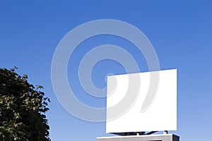 Blank billboard in the city against blue sky