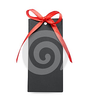 Blank black gift tag with red satin ribbon on white background, top view. Space for design