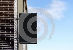 Blank black light box mockup on brick wall, sky background