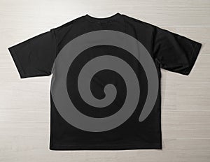 Blank Black Oversized T-shirt mockup template on the floor.