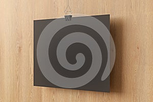 Blank black paper poster hanging on binder clip