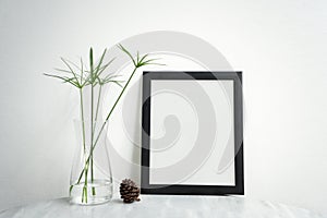 Blank Black Photo Frame and vase on table for Design Mockup