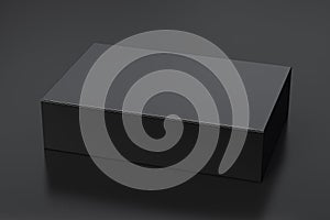 Blank black wide flat box with closed hinged flap lid on black background.