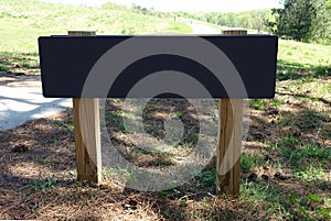 Blank Black Wood Sign on the Side of a Trail