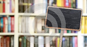 Blank blackboard label and blurred library in the background