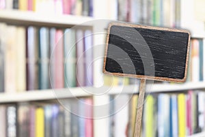 Blank blackboard label and blurred library in the background