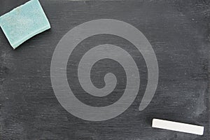 Blank blackboard with white chalks and eraser.