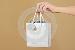 Blank blue paper gift bag with hearts mock up holding in hand. E