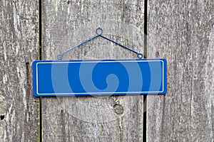 Blank blue sign on old rustic wooden fence