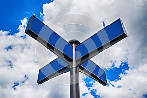 Blank blue traffic road signs in bright sky with clouds.