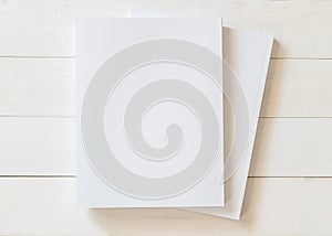 Blank book cover template with page in front side standing on white wood background flat lay