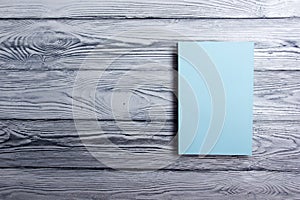 Blank book cover on textured wood background. Copy space