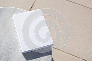 blank book for mockup design on marble table by the swimming pool