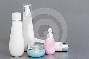 Blank bottle packaging with natural cosmetic cream, serum, skincare, lotion, tonic. bio organic product on gray background. spa