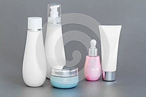 Blank bottle packaging with natural cosmetic cream, serum, skincare, lotion, tonic. bio organic product on gray background. spa