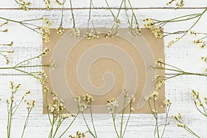 Blank brown card decorated with yellow limonium caspia flowers