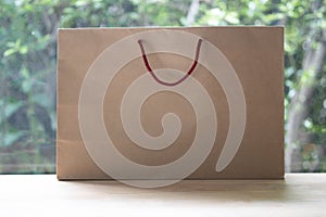 Blank brown paper bag with red handle