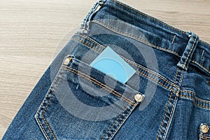 Blank business card with copy space in a pocket of blue worn out jeans