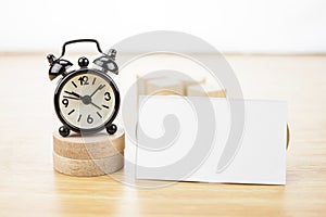Blank Business card mock up and black alarm clock on light wooden table, Business corporate identity, Clipping path on business c