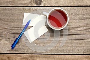 Blank business cards with pen and tea cup on wooden office table