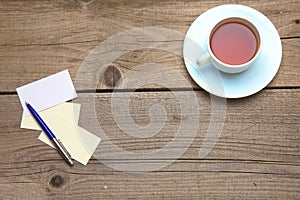 Blank business cards with pen and tea cup on wooden office table