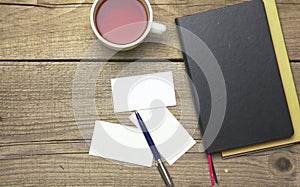 Blank business cards with pen and tea cup on wooden office table