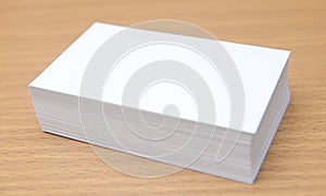 Blank business cards in stack, to replace with own image. on wood table