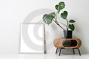 Blank canvas frame mockup on white wall. View of modern scandinavian style interior with artwork mock up on wall