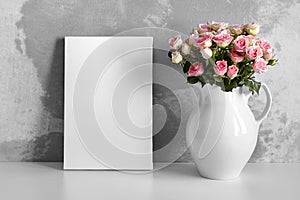 Blank canvas mockup on white table with flowers in pitcher on concrete wall background