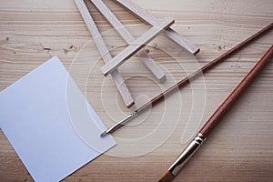 Blank canvas on wooden mini easel in front of nature and paint brushes, art work and inspiration concept