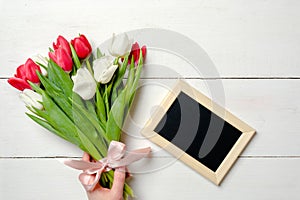 Blank card for invitation or congratulation with bunch of tulips flowers on white wooden table. Vintage banner mockup for spring h