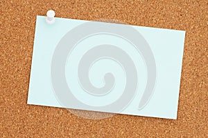 Blank card paper with a pushpin on a corkboard