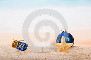 A blank card on peg, Christmas ball and gifts, starfish in the s