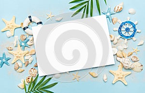 Blank card surrounded by seashells and starfish on sandy beach